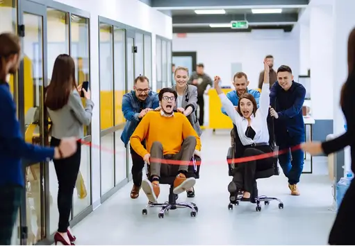 Home 2 Office employees having a good time in a chair race During Tech-based Team Building